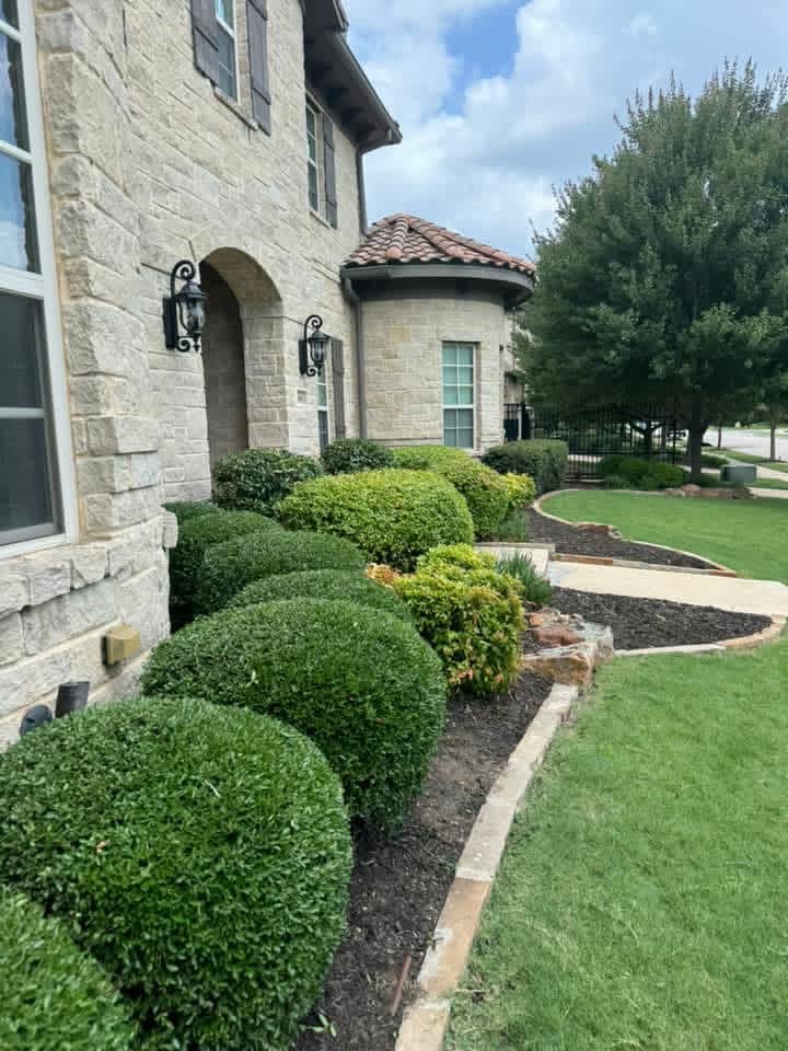 Manicured shrubs and flower beds along a home — Prestige Lawn & Landscaping